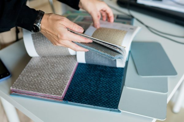 woman-choosing-fabrics-swatches-for-sofa-in-store-2024-12-01-07-53-20-utc
